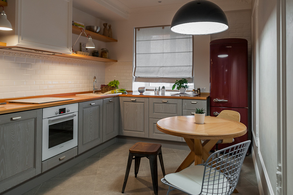 Design ideas for a small scandinavian l-shaped eat-in kitchen in Other with an undermount sink, raised-panel cabinets, grey cabinets, wood benchtops, white splashback, subway tile splashback, white appliances, porcelain floors, grey floor and yellow benchtop.