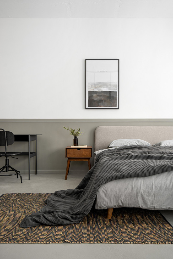Imagen de dormitorio pequeño con paredes blancas, suelo de cemento, suelo gris y panelado