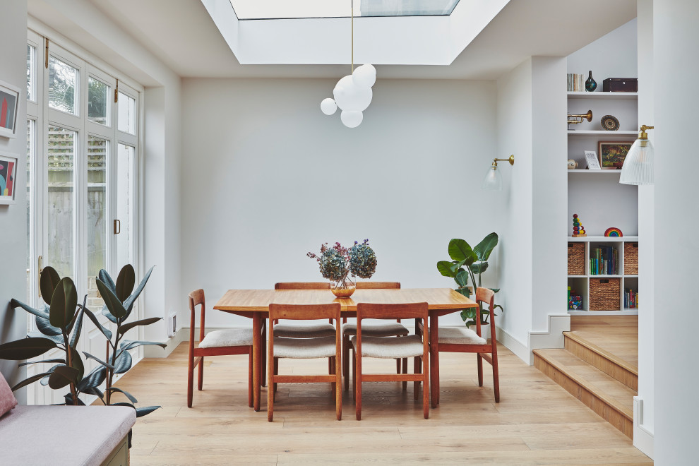 Aménagement d'une salle à manger ouverte sur le salon moderne de taille moyenne avec un mur gris, parquet clair et éclairage.