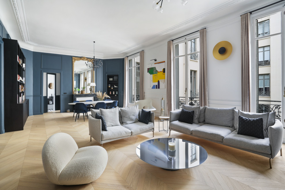 Cette image montre un grand salon gris et jaune design avec un mur bleu, parquet clair, un téléviseur dissimulé et du papier peint.
