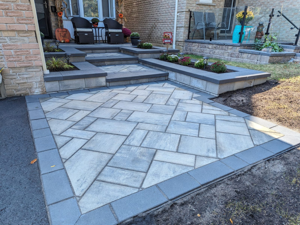 This is an example of a medium sized modern front driveway partial sun garden for spring in Toronto with a pathway and concrete paving.