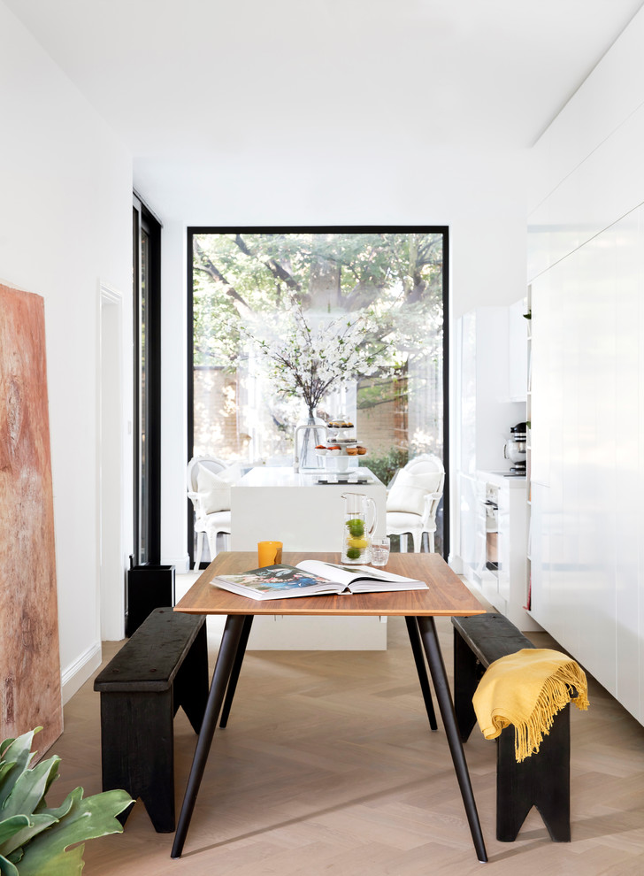 Mid-sized contemporary dining room in London with white walls and light hardwood floors.