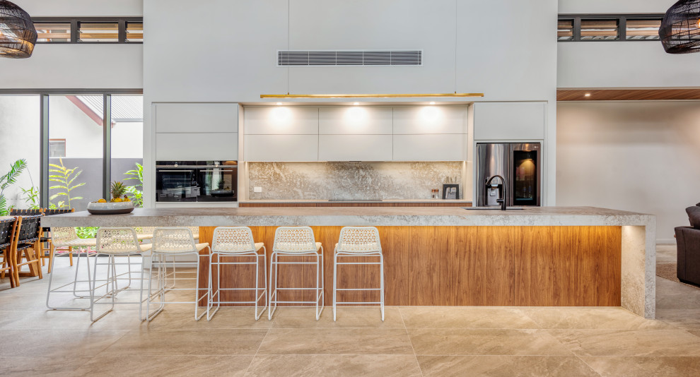 Foto di un'ampia cucina design con ante lisce, ante bianche, paraspruzzi grigio, elettrodomestici in acciaio inossidabile, pavimento beige e top grigio