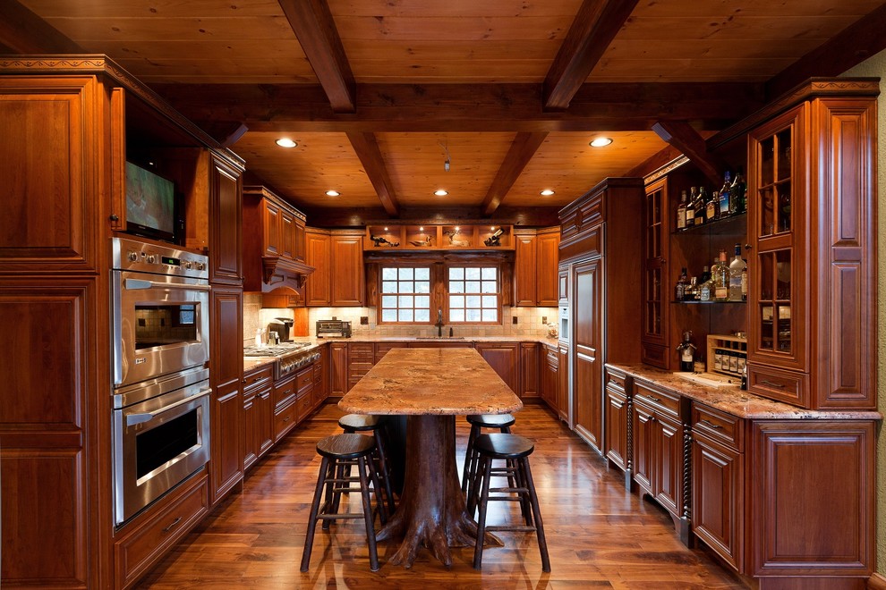Inspiration for a traditional u-shaped kitchen in New York with raised-panel cabinets, dark wood cabinets, stainless steel appliances and medium hardwood floors.