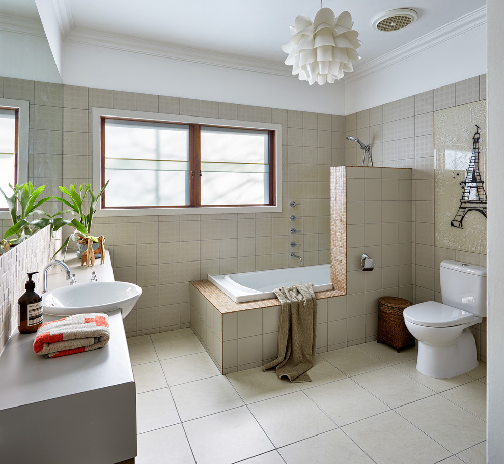 This is an example of a mid-sized contemporary master bathroom in Melbourne with recessed-panel cabinets, white cabinets, a drop-in tub, a shower/bathtub combo, a one-piece toilet, beige tile, ceramic tile, white walls, ceramic floors, a drop-in sink, solid surface benchtops, grey benchtops, beige floor and an open shower.
