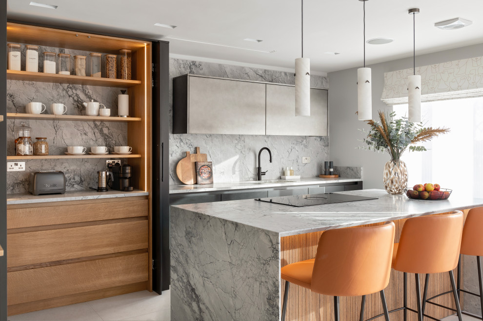 Design ideas for a contemporary galley kitchen in Hertfordshire with a submerged sink, flat-panel cabinets, grey cabinets, grey splashback, stone slab splashback, an island, grey floors and grey worktops.