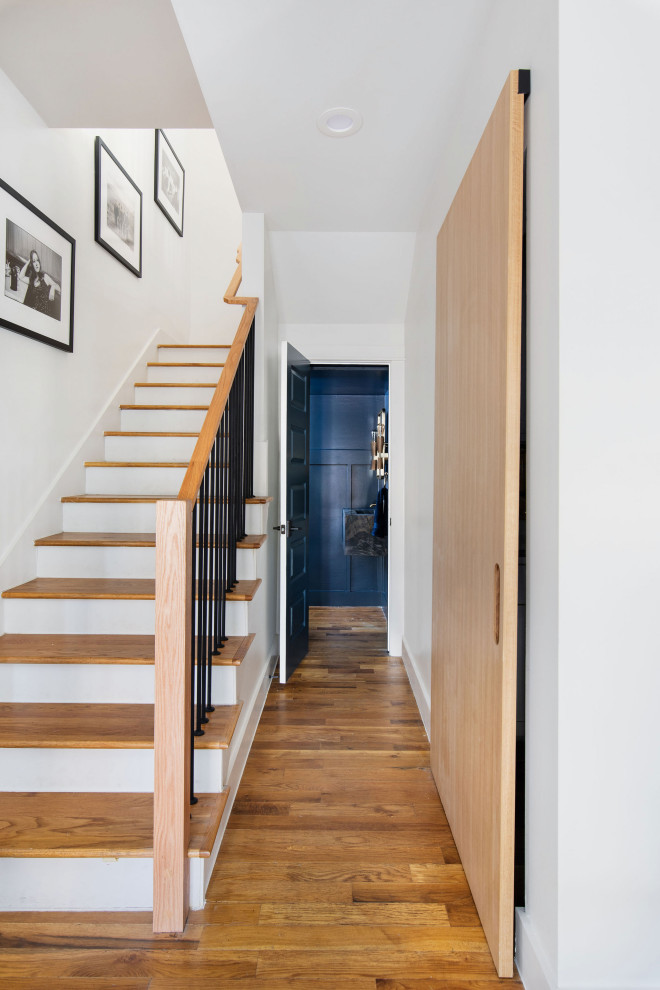Hallway - small transitional medium tone wood floor, brown floor and wainscoting hallway idea in Austin with white walls