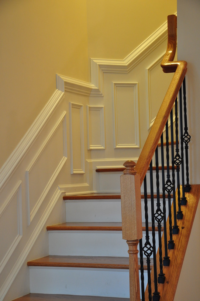 Small traditional wood curved staircase in Richmond with painted wood risers and metal railing.