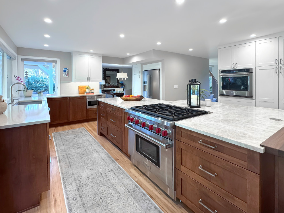 Eat-in kitchen - large transitional u-shaped light wood floor and beige floor eat-in kitchen idea in Seattle with a single-bowl sink, shaker cabinets, medium tone wood cabinets, quartzite countertops, white backsplash, ceramic backsplash, stainless steel appliances, an island and beige countertops