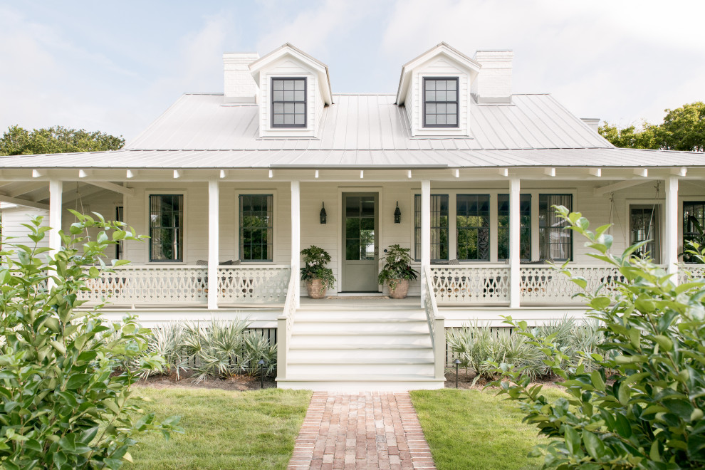 Sullivan's Island Remodel - Historic exterior struction of Sullivan's Island home, exposed rafters, painted wood porches, decorative lanterns, and nostalgic custom stair railing design