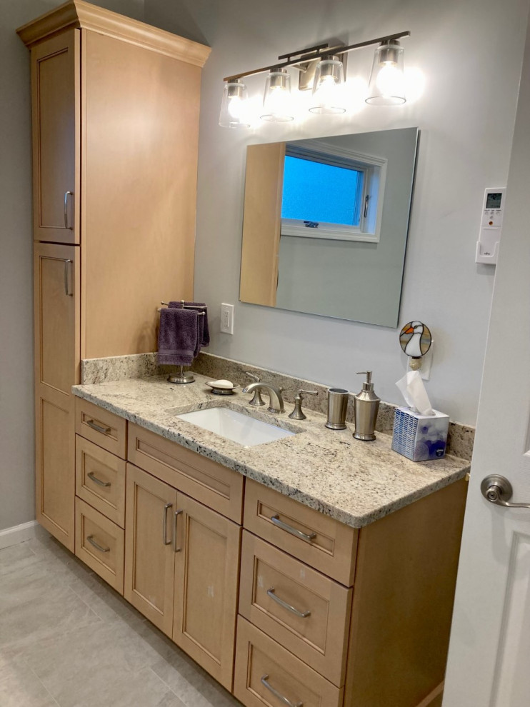 Mid-sized transitional master white tile and ceramic tile porcelain tile, gray floor and single-sink double shower photo in New York with shaker cabinets, light wood cabinets, gray walls, an undermount sink, granite countertops, a hinged shower door, white countertops and a built-in vanity