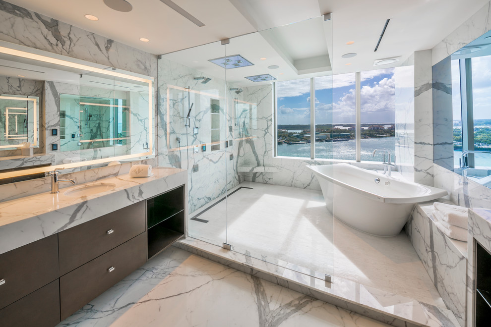 Design ideas for a contemporary master bathroom in Miami with flat-panel cabinets, dark wood cabinets, a freestanding tub, a double shower, gray tile, white tile, an undermount sink and an open shower.