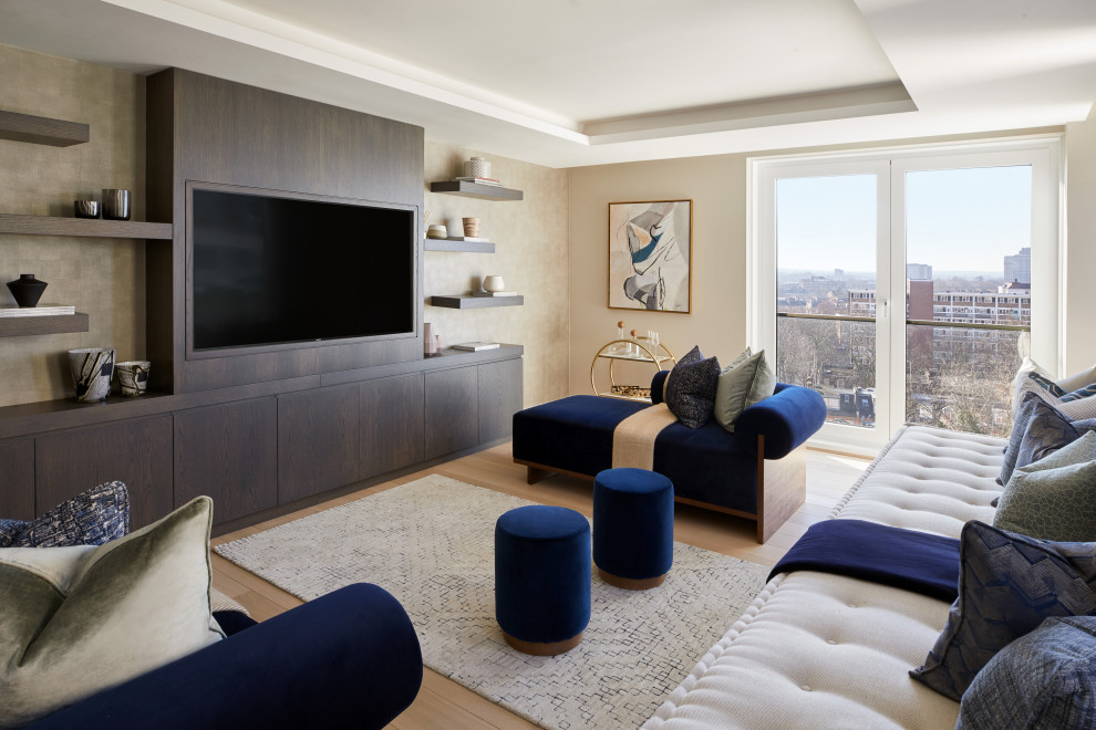 This is an example of a contemporary family room in London with beige walls, light hardwood floors, no fireplace, a built-in media wall and recessed.