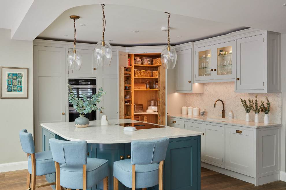 Photo of a mid-sized transitional l-shaped open plan kitchen in Surrey with an undermount sink, shaker cabinets, blue cabinets, marble benchtops, grey splashback, marble splashback, coloured appliances, ceramic floors, with island, brown floor and grey benchtop.