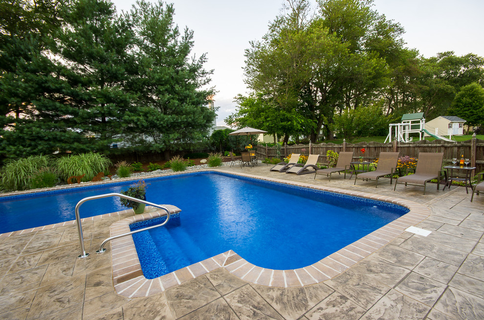 Inspiration for a backyard l-shaped natural pool in Wilmington with stamped concrete.