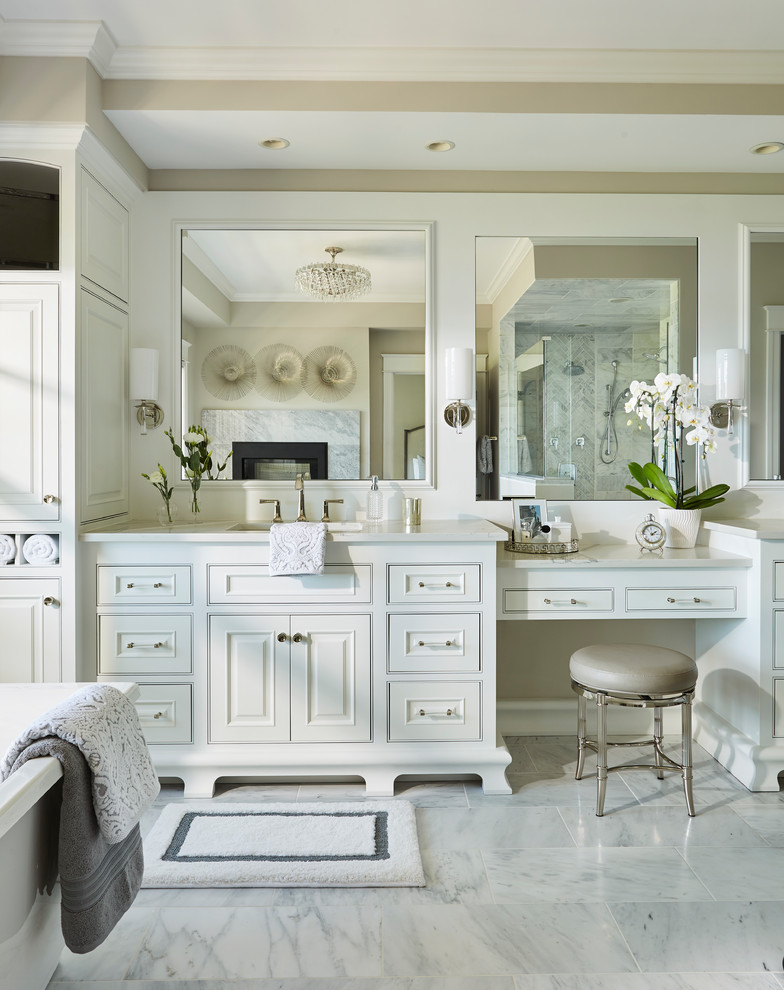Expansive traditional master bathroom in Minneapolis with white cabinets, a freestanding tub, a corner shower, gray tile, marble, beige walls, marble floors, an undermount sink, quartzite benchtops, white floor, a hinged shower door, white benchtops and beaded inset cabinets.