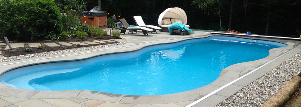 Design ideas for a large modern backyard custom-shaped natural pool in Burlington with a pool house and natural stone pavers.