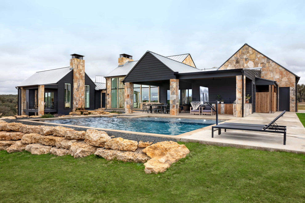 Modelo de piscinas y jacuzzis de estilo de casa de campo rectangulares en patio trasero con losas de hormigón