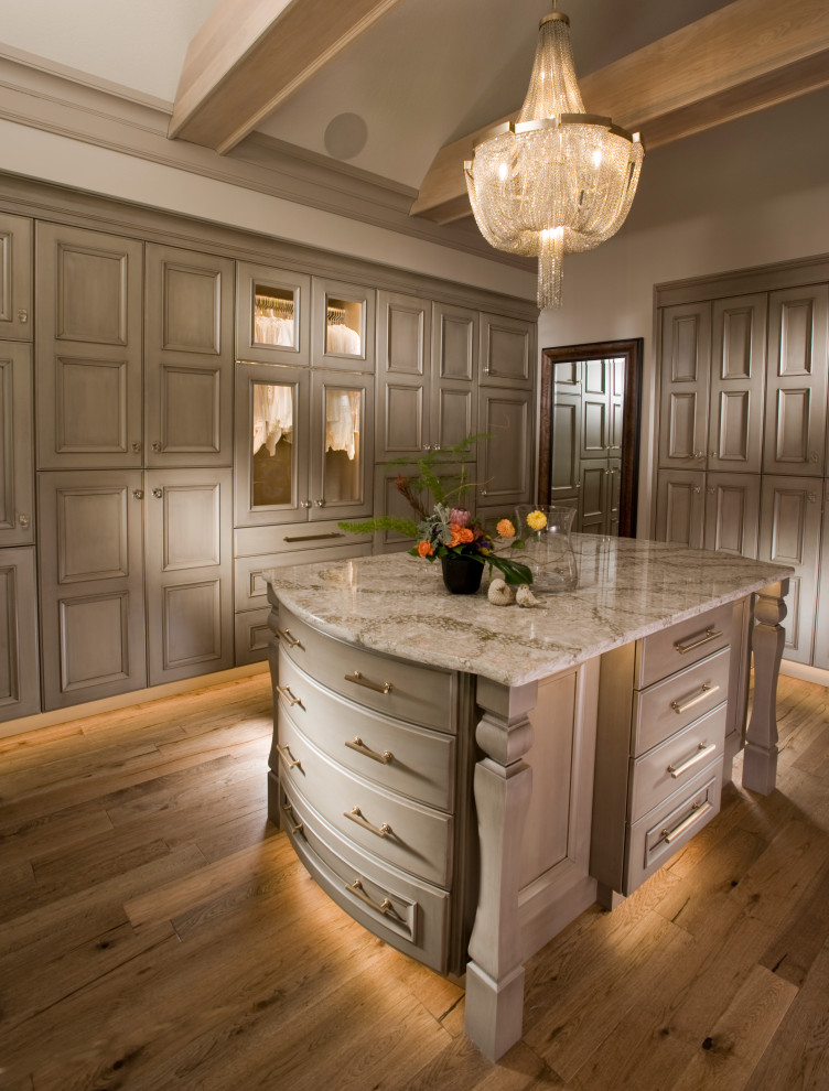 Design ideas for a large traditional gender-neutral dressing room in Wichita with recessed-panel cabinets, beige cabinets, medium hardwood floors and brown floor.