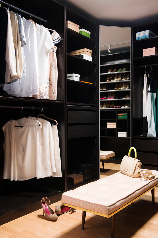 Inspiration for a large modern gender-neutral walk-in wardrobe in Los Angeles with flat-panel cabinets and light hardwood floors.