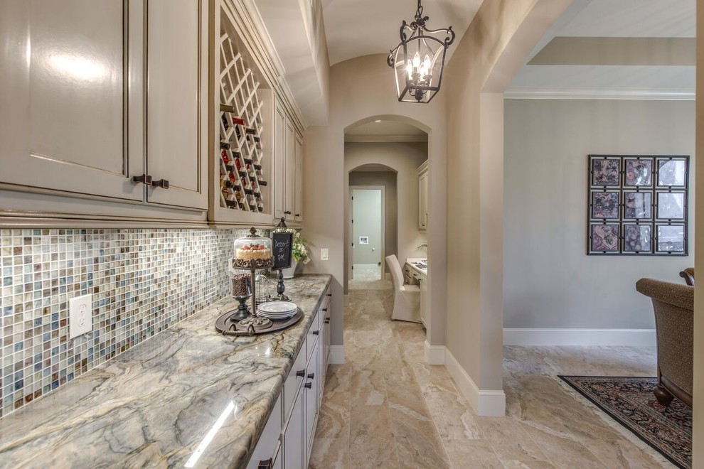 Photo of a mid-sized transitional single-wall wet bar in Houston with no sink, recessed-panel cabinets, grey cabinets, marble benchtops, multi-coloured splashback, mosaic tile splashback and limestone floors.