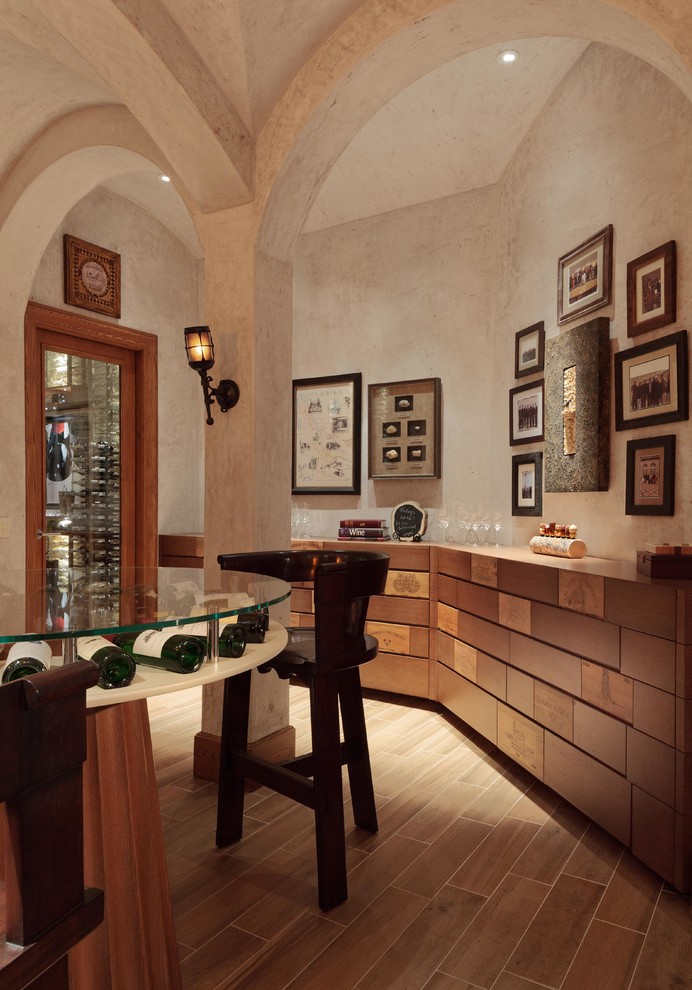 Photo of an expansive mediterranean wine cellar in Tampa with light hardwood floors and storage racks.