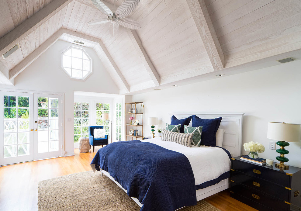 Photo of a beach style master bedroom in Chicago with white walls and medium hardwood floors.
