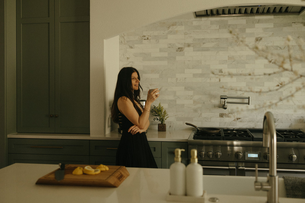 Example of a transitional l-shaped dark wood floor and brown floor eat-in kitchen design in Portland with a farmhouse sink, shaker cabinets, green cabinets, quartz countertops, multicolored backsplash, marble backsplash, stainless steel appliances, an island and white countertops