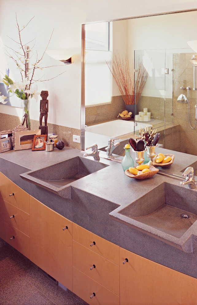 Photo of a large modern master bathroom in San Francisco with flat-panel cabinets, light wood cabinets, a drop-in tub, a corner shower, beige walls, an integrated sink, concrete benchtops, a hinged shower door and grey benchtops.