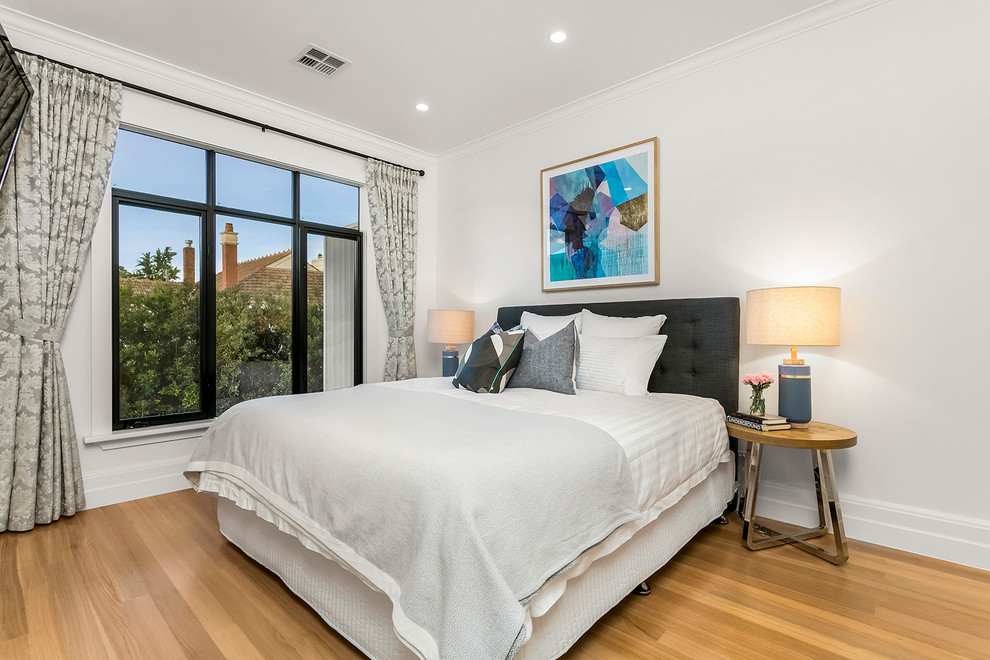Contemporary master bedroom in Melbourne with white walls, light hardwood floors and beige floor.