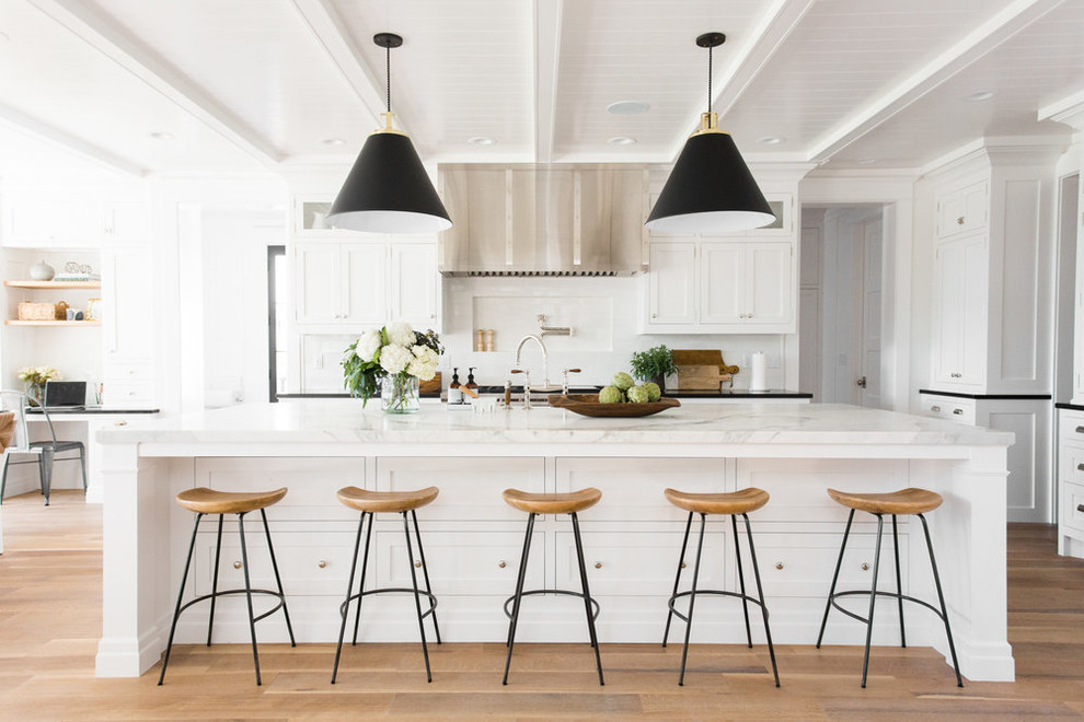 Design ideas for a large beach style kitchen in Salt Lake City with with island, white splashback, shaker cabinets, marble benchtops, light hardwood floors and beige floor.
