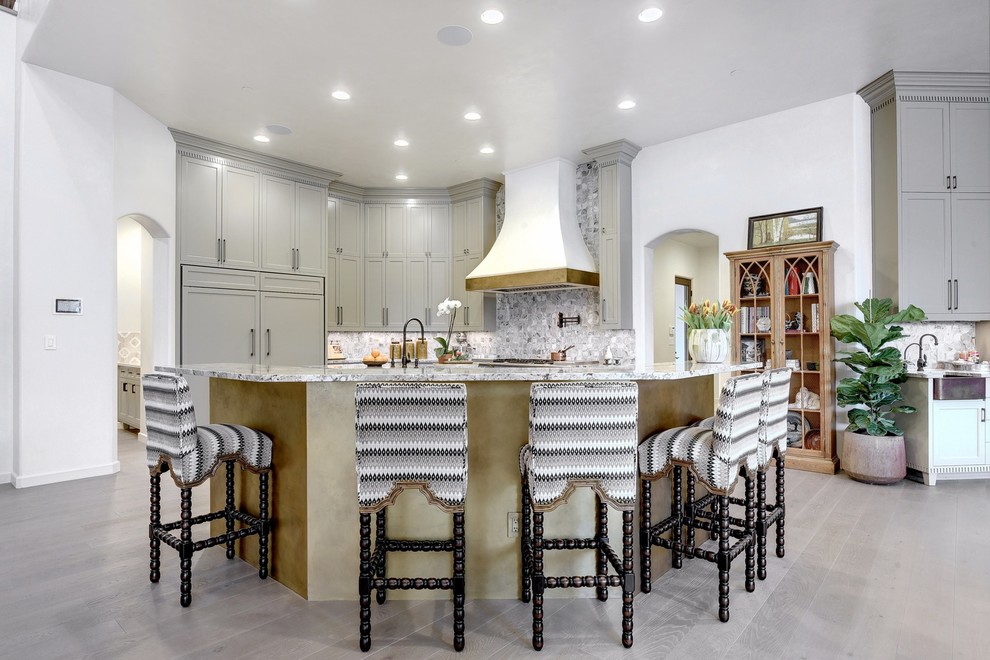 Inspiration for an expansive mediterranean open plan kitchen in Austin with shaker cabinets, granite benchtops, panelled appliances, light hardwood floors, grey cabinets, multi-coloured splashback, with island, beige floor and multi-coloured benchtop.