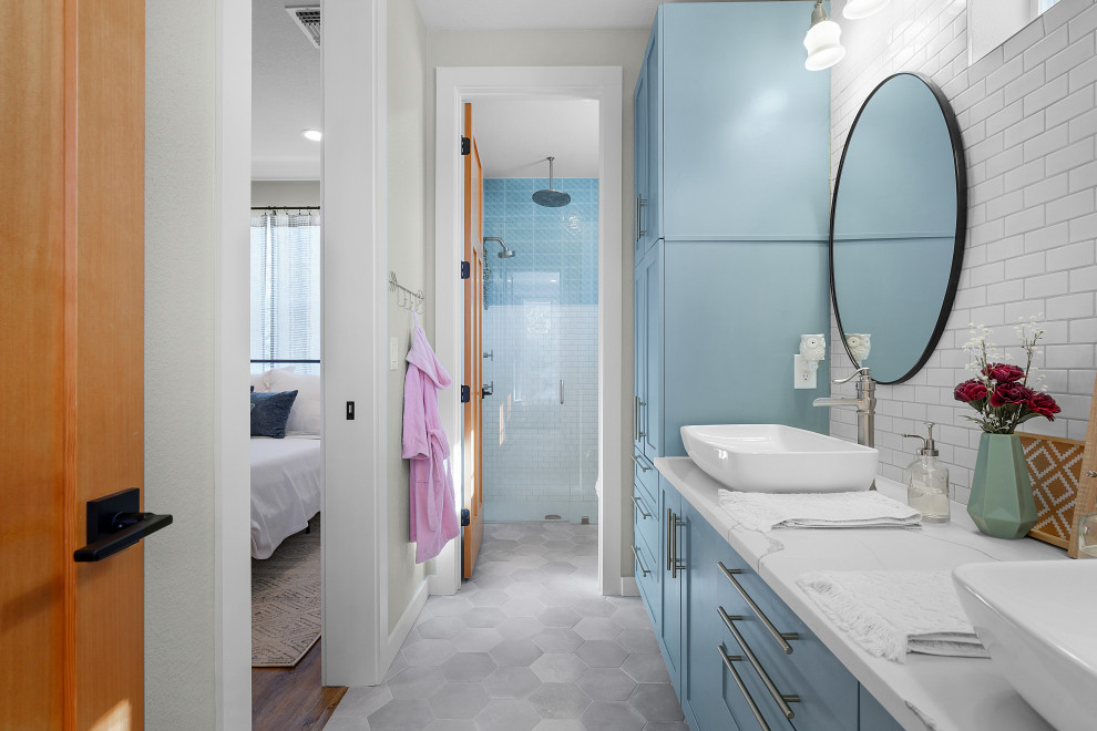 Cette photo montre une salle de bain nature de taille moyenne pour enfant avec des portes de placard bleues, une baignoire indépendante, une douche d'angle, un carrelage blanc, des carreaux de céramique, un mur blanc, un sol en carrelage de terre cuite, une vasque, un plan de toilette en quartz modifié, un plan de toilette blanc, meuble double vasque, meuble-lavabo encastré et un placard à porte shaker.