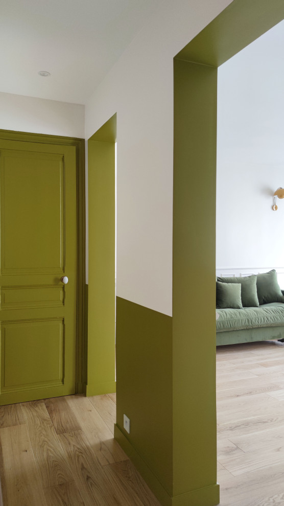 Imagen de distribuidor moderno de tamaño medio con paredes verdes, suelo de madera clara, puerta simple, puerta verde y suelo marrón
