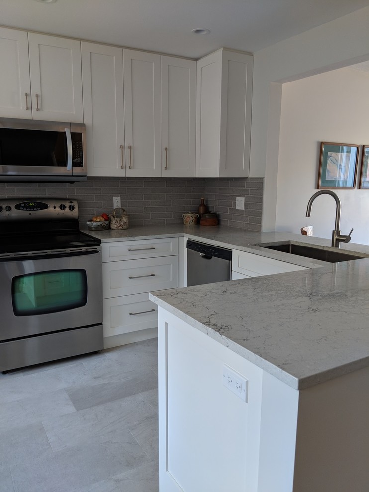 Small transitional u-shaped vinyl floor and beige floor eat-in kitchen photo in Vancouver with a single-bowl sink, shaker cabinets, white cabinets, quartz countertops, gray backsplash, ceramic backsplash, stainless steel appliances, no island and gray countertops