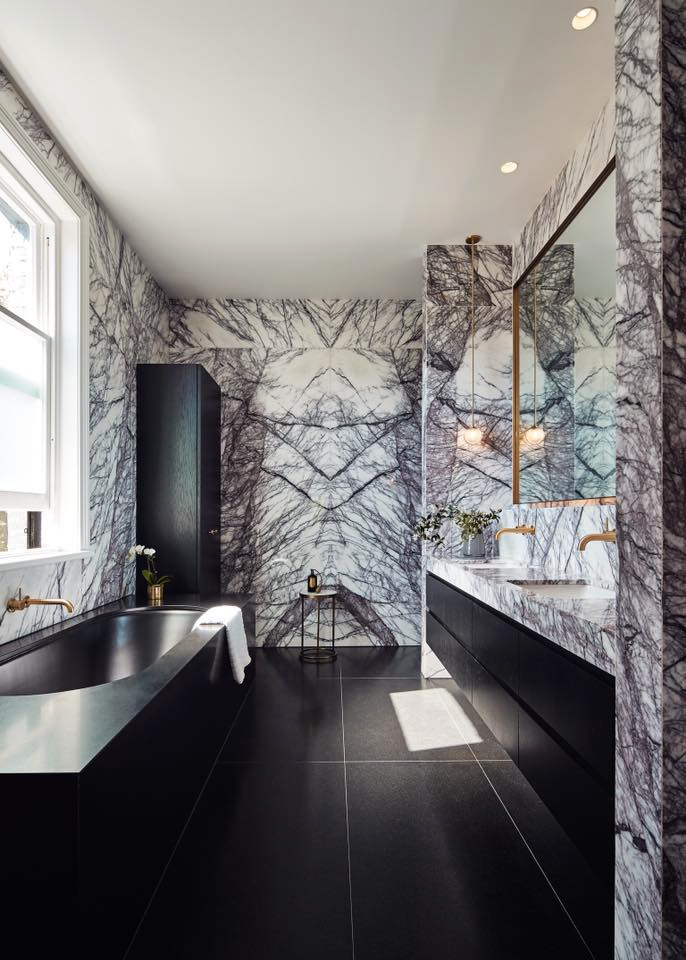 This is an example of a mid-sized contemporary master bathroom in Melbourne with raised-panel cabinets, white cabinets, a drop-in tub, multi-coloured tile, marble, porcelain floors, marble benchtops, black floor and multi-coloured benchtops.