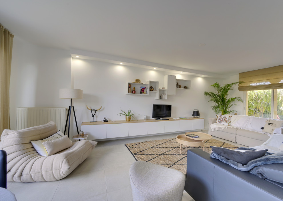 Large transitional open concept living room in Montpellier with white walls, ceramic floors, a freestanding tv and beige floor.