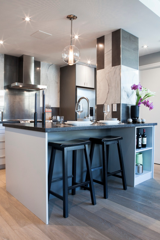 Photo of a small modern galley eat-in kitchen in Toronto with a single-bowl sink, flat-panel cabinets, grey cabinets, wood benchtops, metallic splashback, ceramic splashback, stainless steel appliances, light hardwood floors and with island.