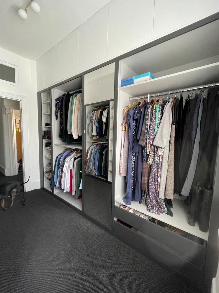 Imagen de armario vestidor de mujer actual grande con armarios con paneles lisos, puertas de armario grises, moqueta y suelo gris