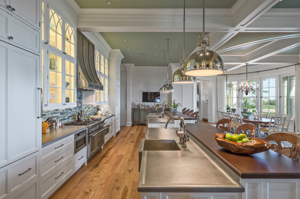 Design ideas for an expansive traditional u-shaped eat-in kitchen in Providence with an integrated sink, recessed-panel cabinets, yellow cabinets, marble benchtops, glass tile splashback, stainless steel appliances, medium hardwood floors and multiple islands.