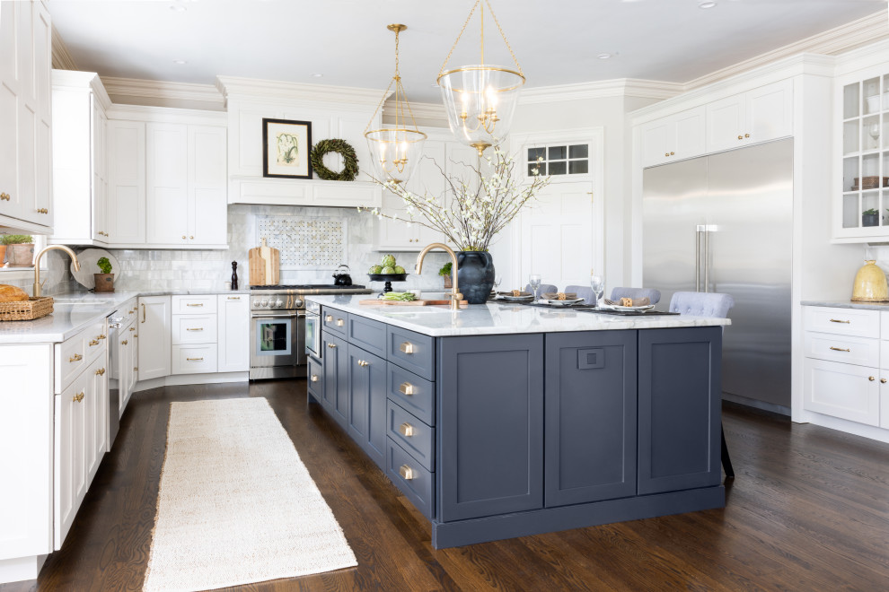 Inspiration for a large traditional u-shaped kitchen pantry in Other with a double-bowl sink, shaker cabinets, white cabinets, quartzite benchtops, white splashback, marble splashback, stainless steel appliances, dark hardwood floors, with island, brown floor and white benchtop.