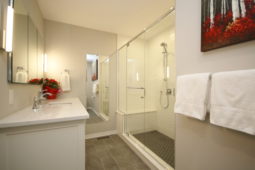 Mid-sized transitional master bathroom in Ottawa with shaker cabinets, white cabinets, an alcove shower, a one-piece toilet, gray tile, porcelain tile, grey walls, porcelain floors, an undermount sink and engineered quartz benchtops.