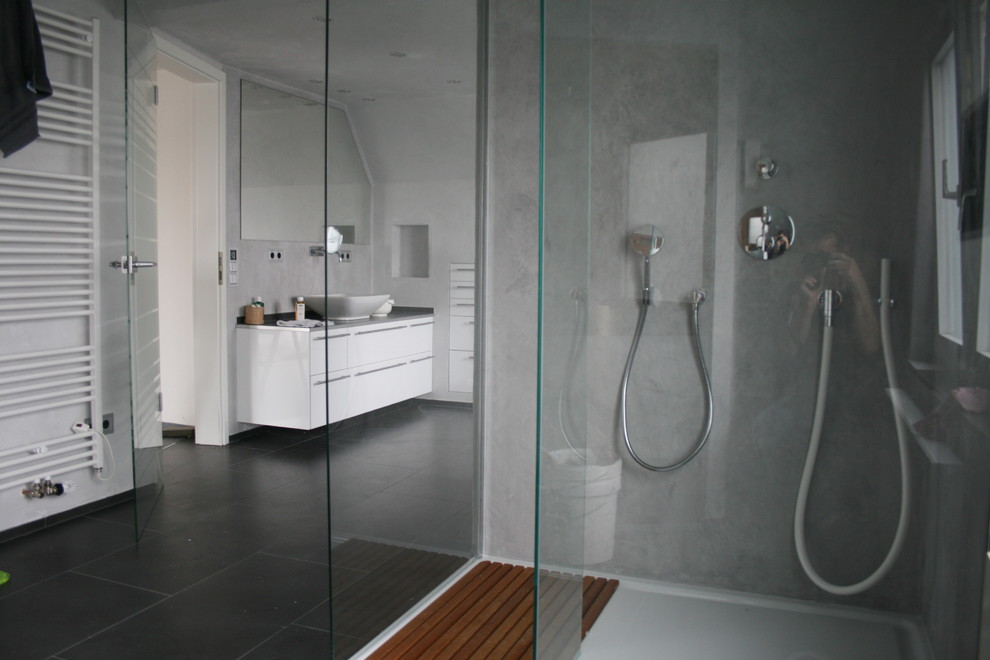 Duschbad With weißen Schränken, bodengleicher Dusche, Fliesen aus Glasscheiben, grauer Wandfarbe, Vinylboden, Aufsatzwaschbecken and Waschtisch aus Holz in Cologne
