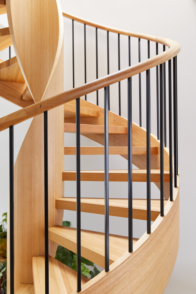 Mid-sized contemporary wood spiral staircase in Melbourne with open risers and wood railing.