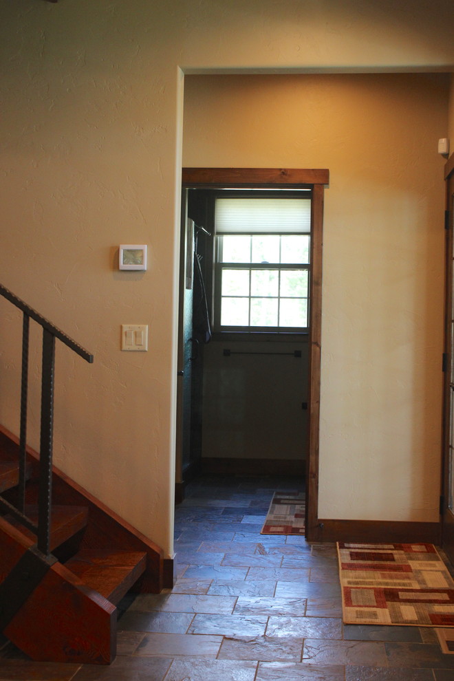 Example of a large transitional slate floor and brown floor hallway design with beige walls