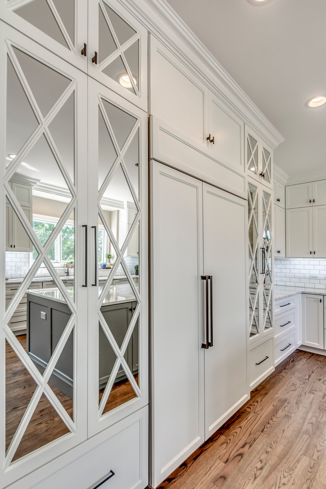 Transitional open concept kitchen photo in Chicago with white backsplash, subway tile backsplash and two islands