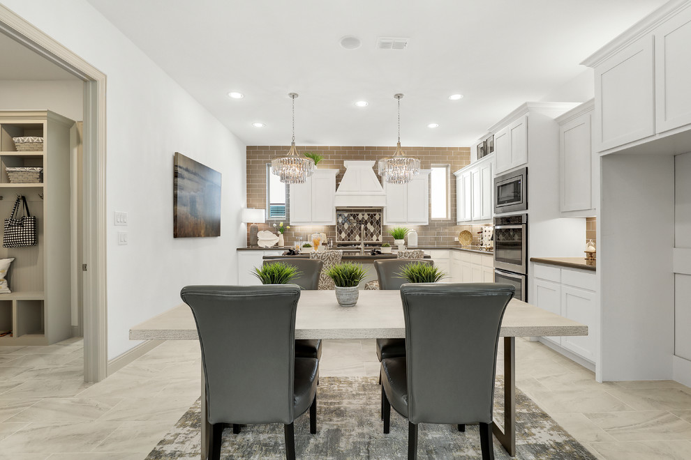 Large traditional l-shaped eat-in kitchen in Dallas with a double-bowl sink, raised-panel cabinets, white cabinets, granite benchtops, beige splashback, subway tile splashback, stainless steel appliances, ceramic floors, with island, beige floor and beige benchtop.