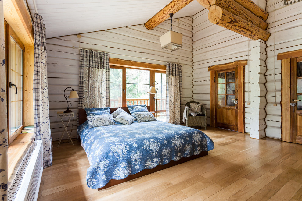 Photo of a country master bedroom in Saint Petersburg with light hardwood floors and white walls.