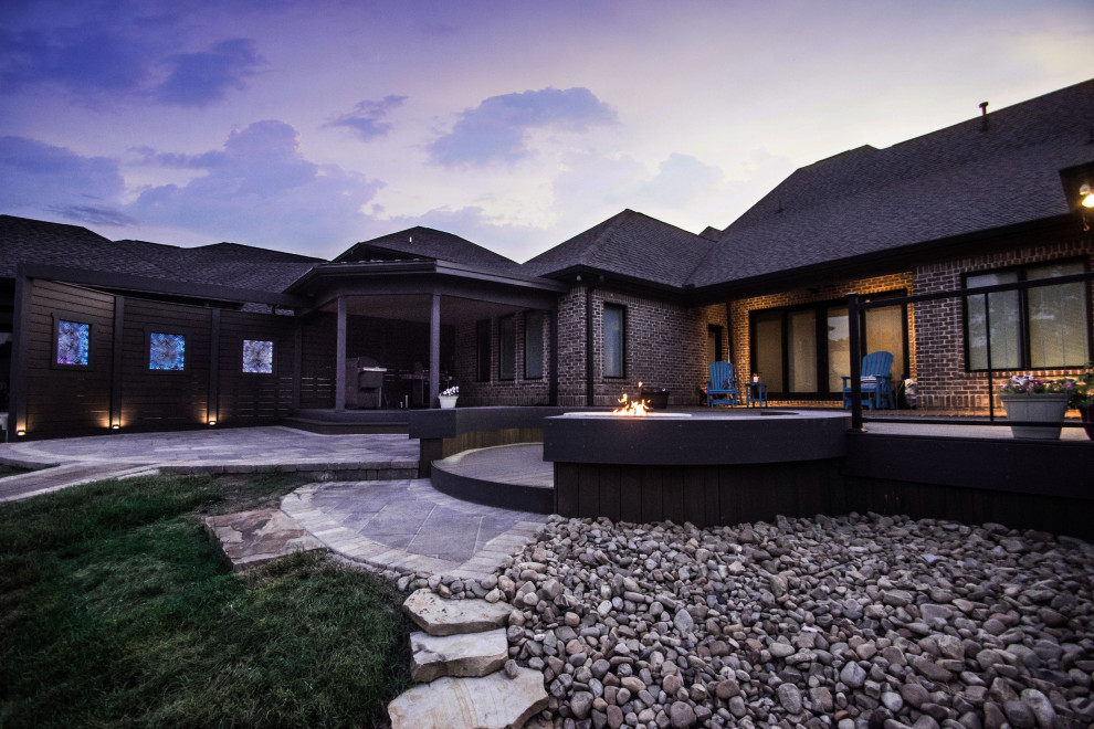 Example of a large transitional backyard deck design with a fire pit and no cover