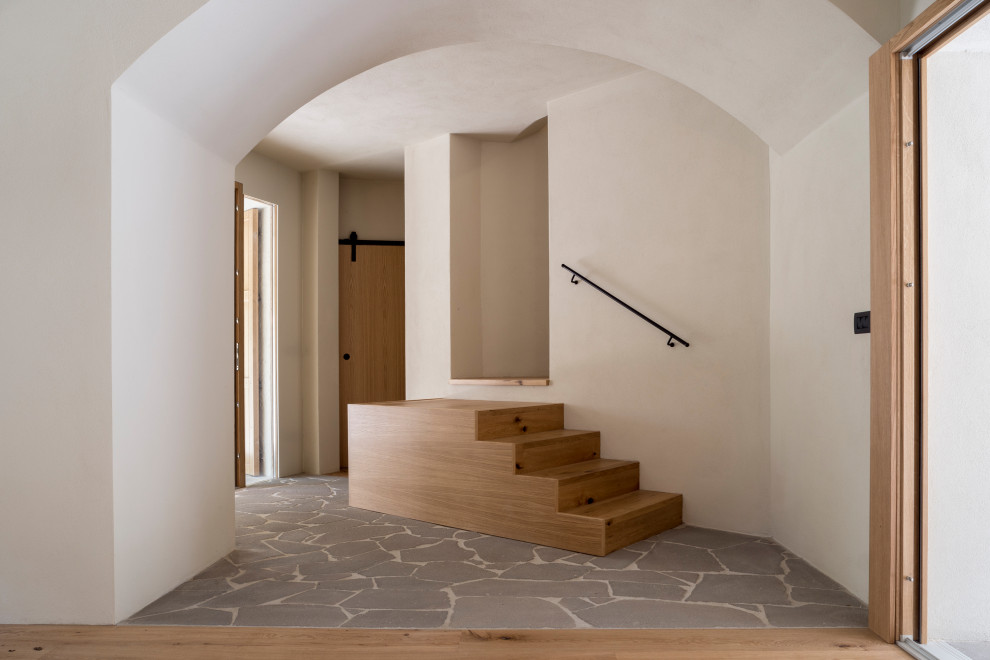 Design ideas for a contemporary foyer in Cagliari with beige walls and a light wood front door.